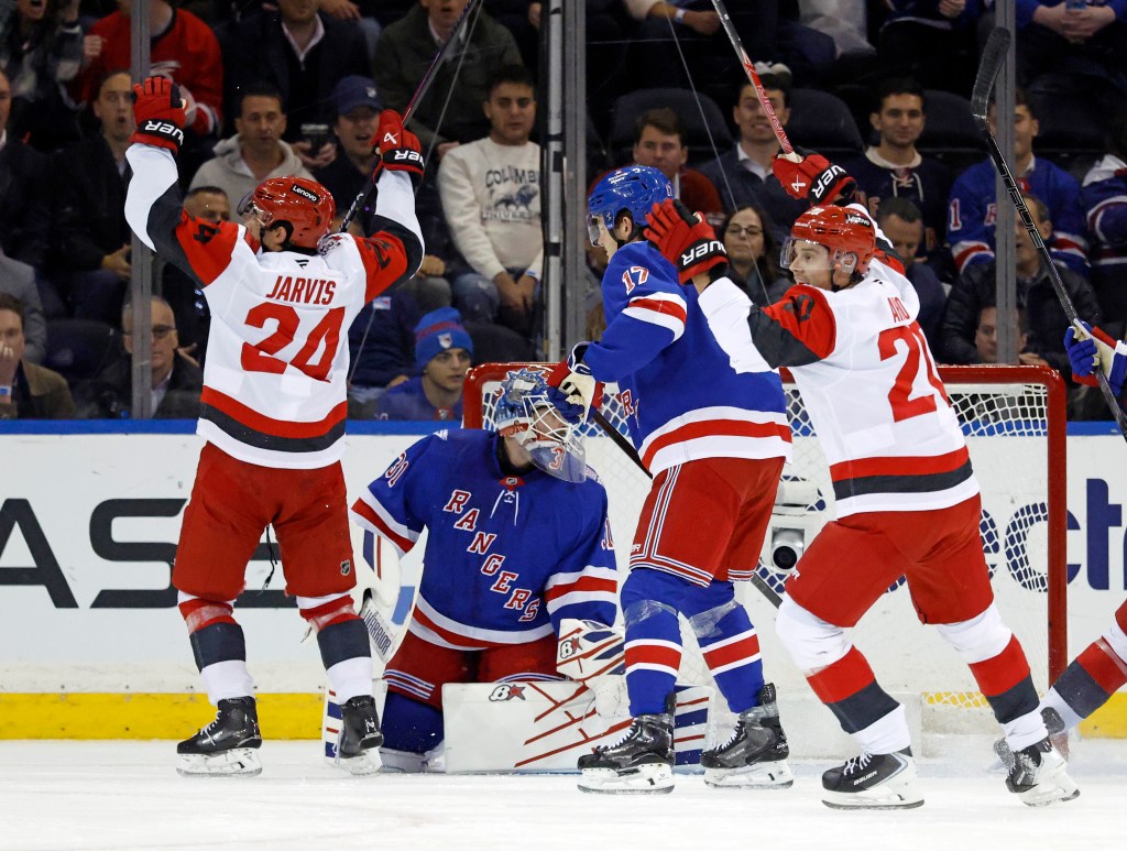 Carolina Hurricanes center Seth Jarvis celebrates a goal with teammate Andrei Svechnikov as New York Rangers goalie Igor Shesterkin and defenseman K'Andre Miller react.