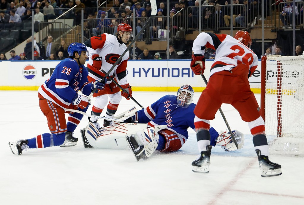 Carolina Hurricanes defenseman Sean Walker scoring a goal past New York Rangers goaltender Igor Shesterkin.