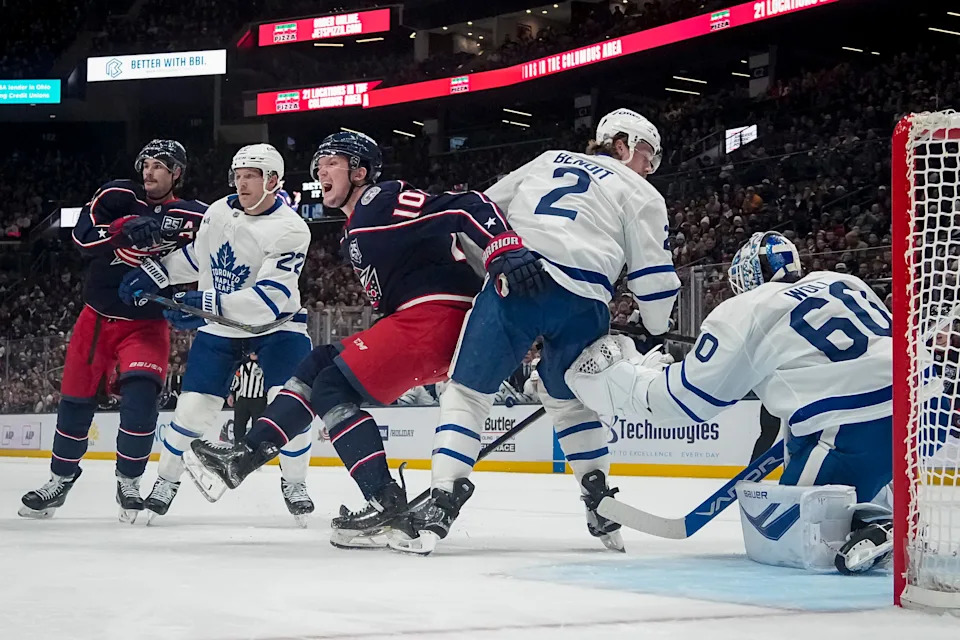 Columbus Blue Jackets left wing Dmitri Voronkov (10) collides with Toronto Maple Leafs defenseman Simon Benoit (2) in front of goaltender Joseph Woll (60) during the NHL hockey game at Nationwide Arena in Columbus on Nov. 26, 2025. The Blue Jackets lost 2-1.