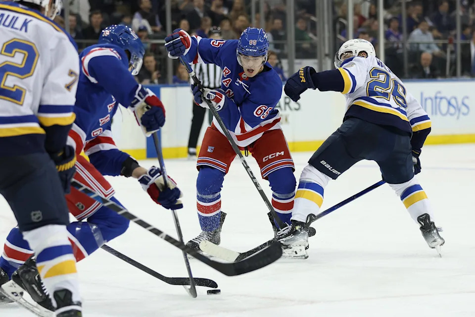 NEW YORK, NEW YORK - NOVEMBER 25: Brett Berard #65 of the New York Rangers skates in his NHL debut as Nathan Walker #26 of the St. Louis Blues defends during the second period at Madison Square Garden on November 25, 2024 in New York City.