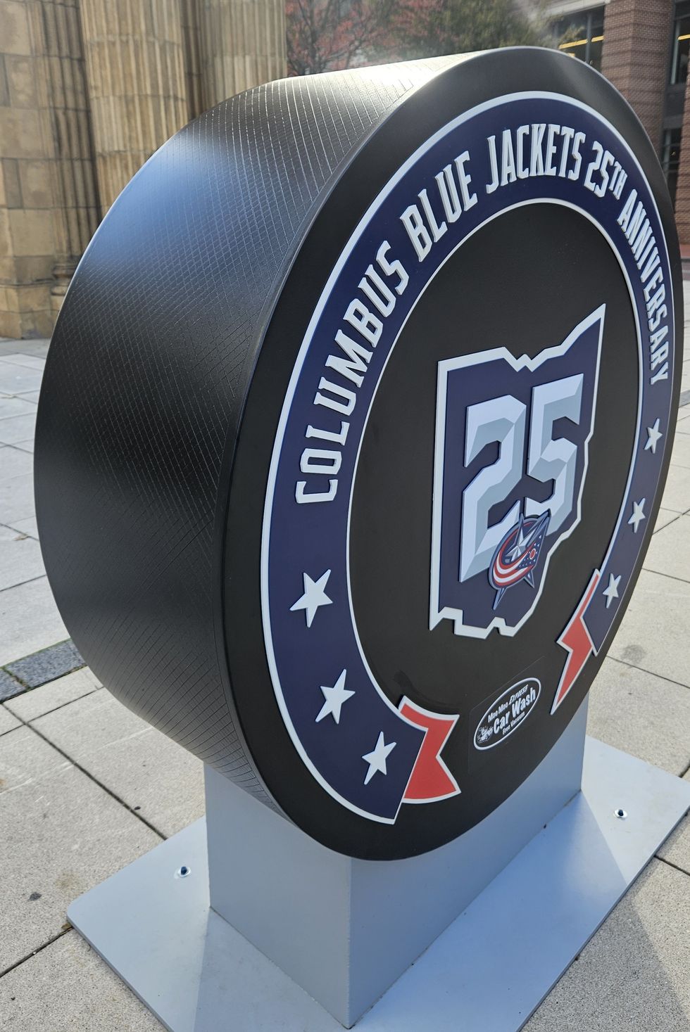 Columbus Blue Jackets 25th Anniversary puck sculpture on sidewalk.