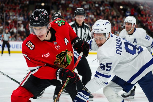 Blackhawks defenseman Connor Murphy, left, and Maple Leafs defenseman Oliver Ekman-Larsson chase after the puck during the second period Saturday, Nov. 15, 2025, at the United Center. (Armando L. Sanchez/Chicago Tribune)