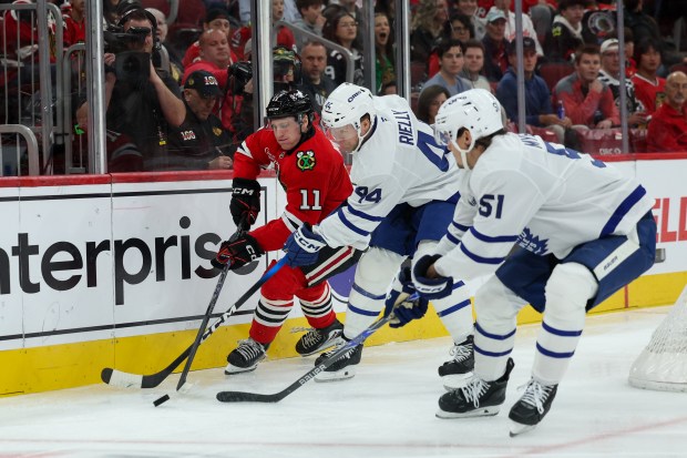 Toronto Maple Leafs defenseman Morgan Rielly (44) and Chicago Blackhawks center Oliver Moore (11) chase after the puck during the first period at the United Center Saturday Nov. 15, 2025 in Chicago. (Armando L. Sanchez/Chicago Tribune)
