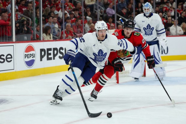 Toronto Maple Leafs defenseman Jake McCabe (22) and Chicago Blackhawks center Ryan Greene (20) chase after the puck during the first period at the United Center Saturday Nov. 15, 2025 in Chicago. (Armando L. Sanchez/Chicago Tribune)