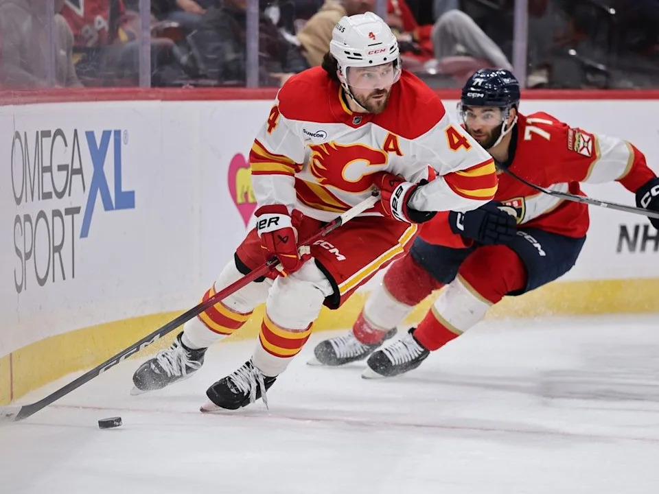 Flames defenceman Rasmus Anderssoncontrols the puck ahead of Panthers forward Luke Kunin.