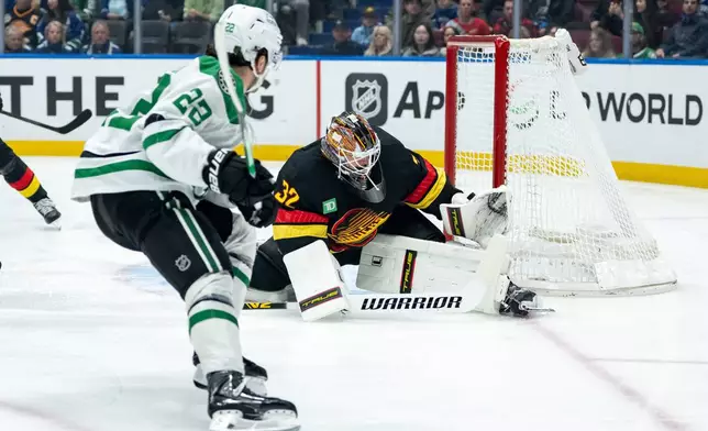 Dallas Stars' Mavrik Bourque (22) scores on Vancouver Canucks goaltender Kevin Lankinen (32) during the first period of an NHL hockey game in Vancouver, Thursday, Nov. 20, 2025. (Ethan Cairns/The Canadian Press via AP)