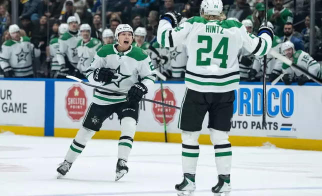 Dallas Stars' Jason Robertson, left, celebrates after his goal against the Vancouver Canucks with Roope Hintz (24) during the first period of an NHL hockey game in Vancouver, Thursday, Nov. 20, 2025. (Ethan Cairns/The Canadian Press via AP)