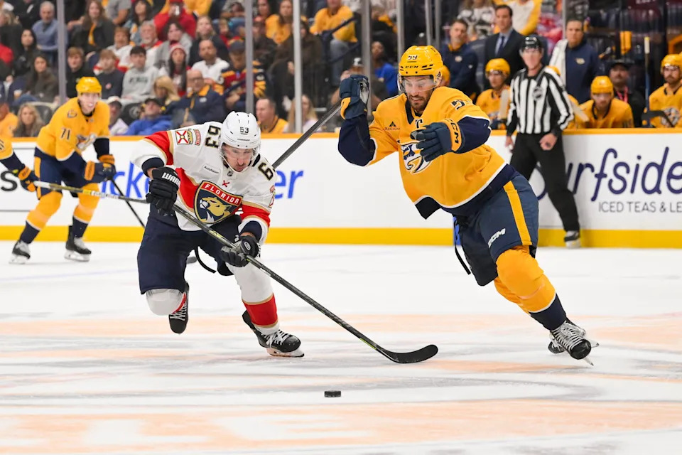 Nov 24, 2025; Nashville, Tennessee, USA; Florida Panthers left wing Brad Marchand (63) and Nashville Predators defenseman Roman Josi (59) battle for the puck during the second period at Bridgestone Arena. Mandatory Credit: Steve Roberts-Imagn Images