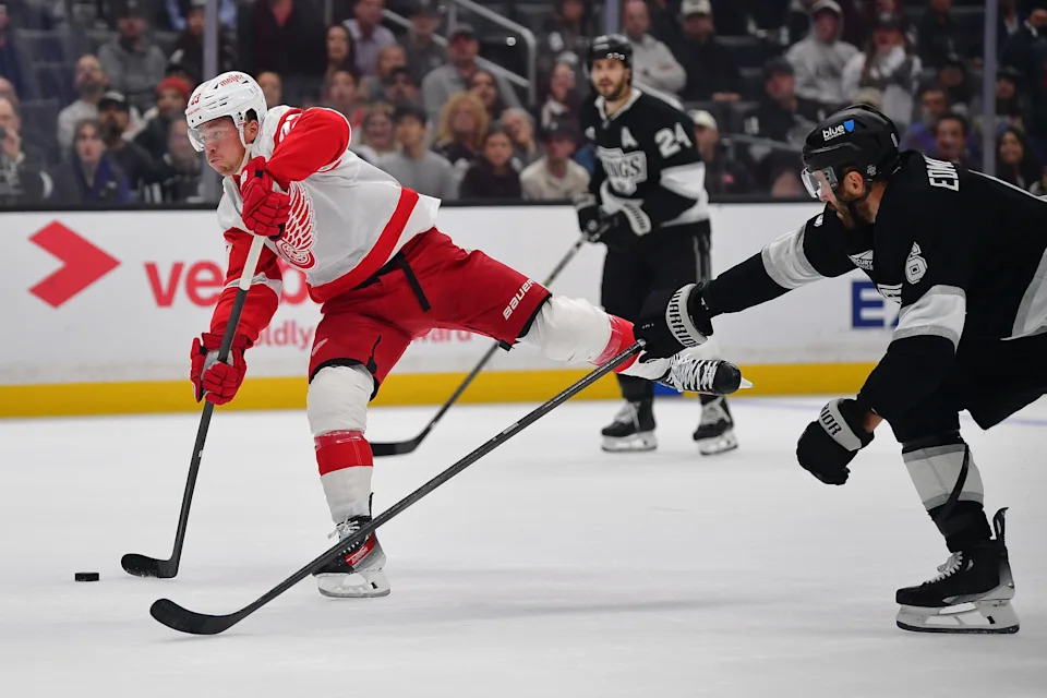 Detroit Red Wings left wing Lucas Raymond (23) shoots on goal ahead of Los Angeles Kings defenseman Joel Edmundson (6) during the first period at Crypto.com Arena in Los Angeles on Thursday, Oct 30, 2025.
