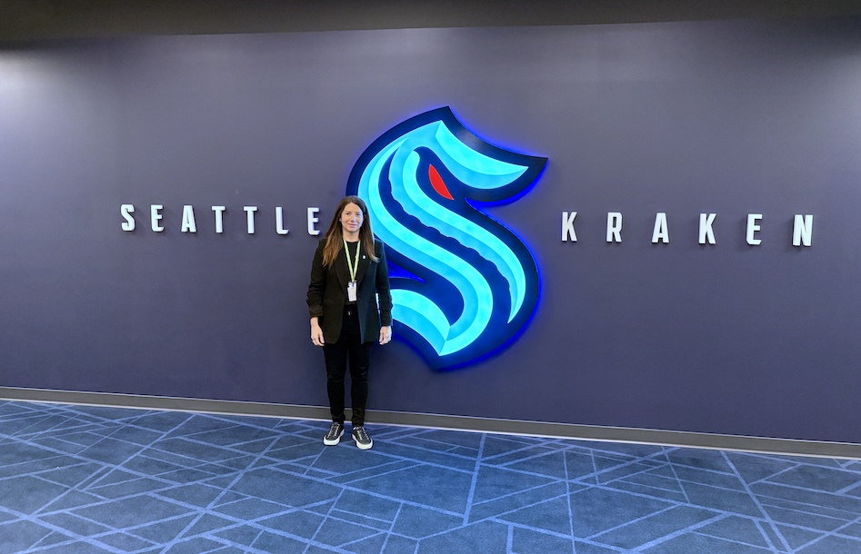 Katie Townsend stands next to Seattle Kraken signage