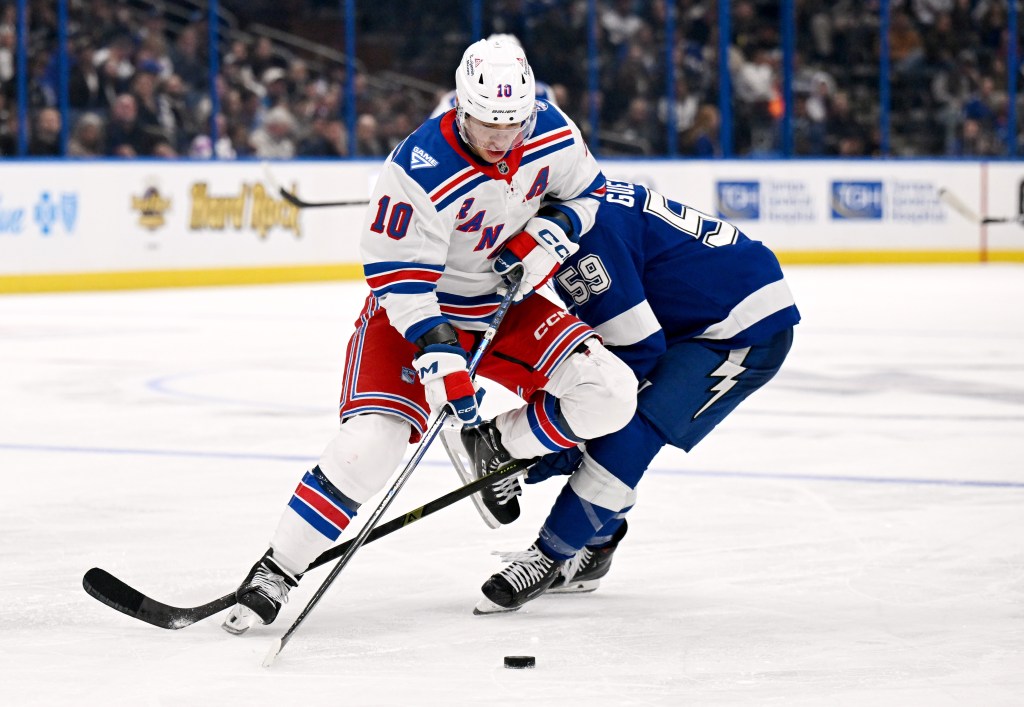 New York Rangers player Artemi Panarin (10) entangled with Tampa Bay Lightning player Jake Guentzel (59) during an NHL game.