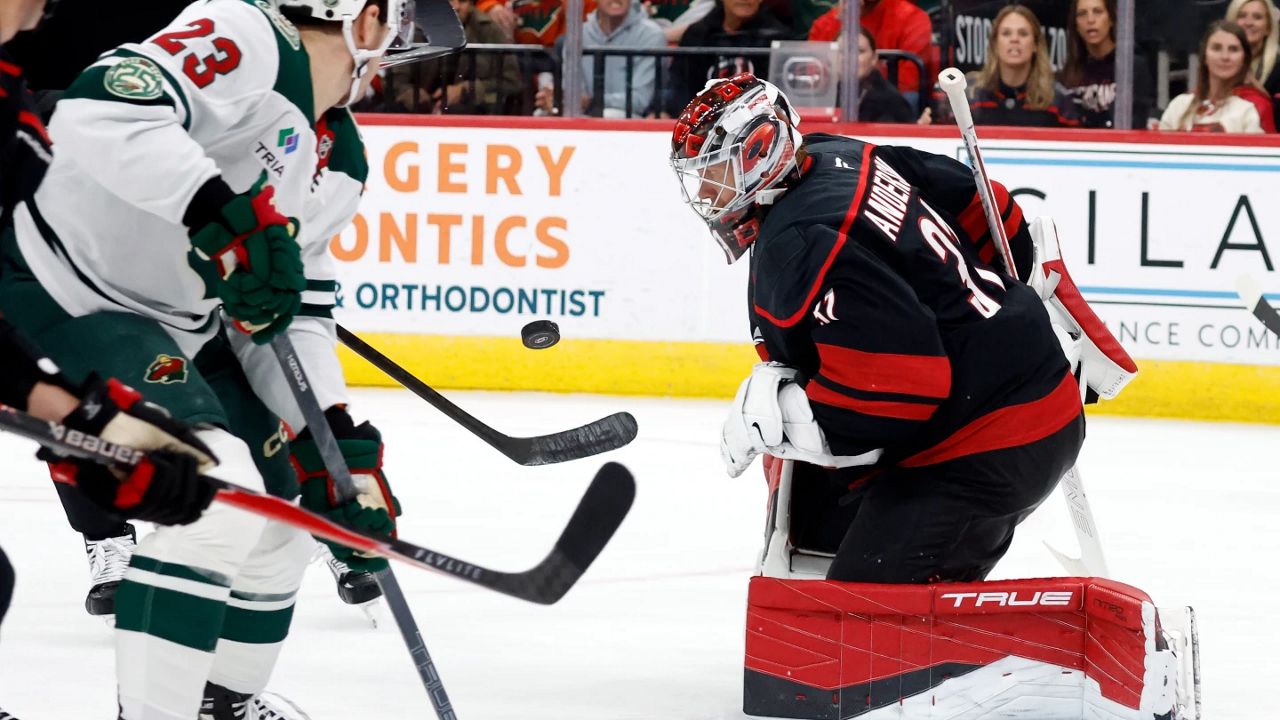 Carolina Hurricanes goaltender Frederik Andersen (31) watches the puck with Minnesota Wild's Marco Rossi (23) nearby during the third period of an NHL hockey game in Raleigh, N.C., Thursday, Nov. 6, 2025. (AP Photo/Karl DeBlaker)