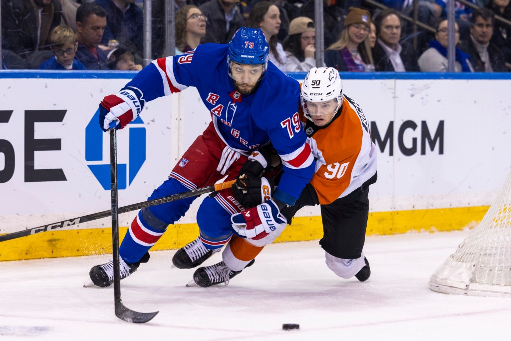 New York Rangers defenseman K'Andre Miller (79) leans on Philadelphia Flyers Anthony Richard (90) with the puck nearby.