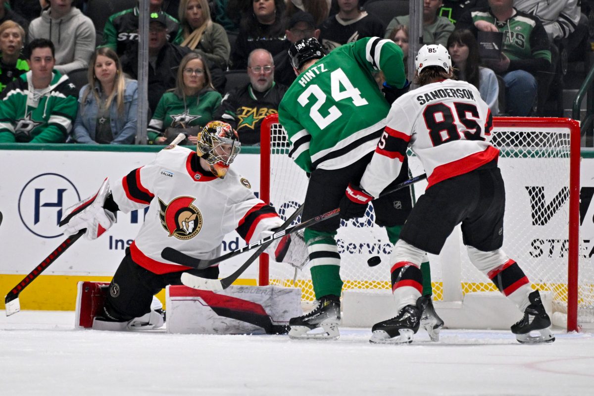 Jan 2, 2025; Dallas, Texas, USA; Dallas Stars center Roope Hintz (24) looks to poke the puck past Ottawa Senators goaltender Leevi Merilainen (1) and defenseman Jake Sanderson (85) during the first period at the American Airlines Center. Mandatory Credit: Jerome Miron-Imagn Images