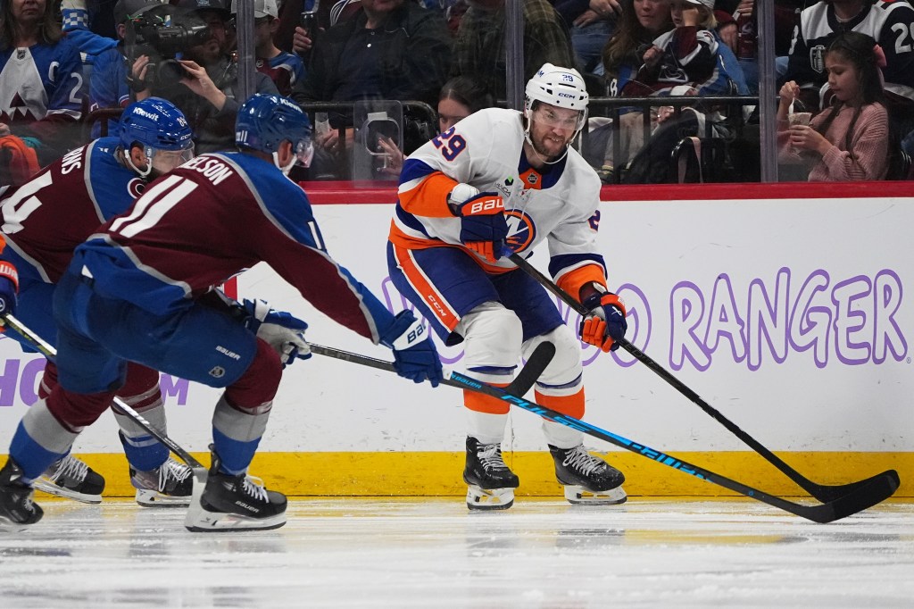 Islanders left wing Jonathan Drouin collects the puck as Avalanche center Brock Nelson and defenseman Brent Burns cover.