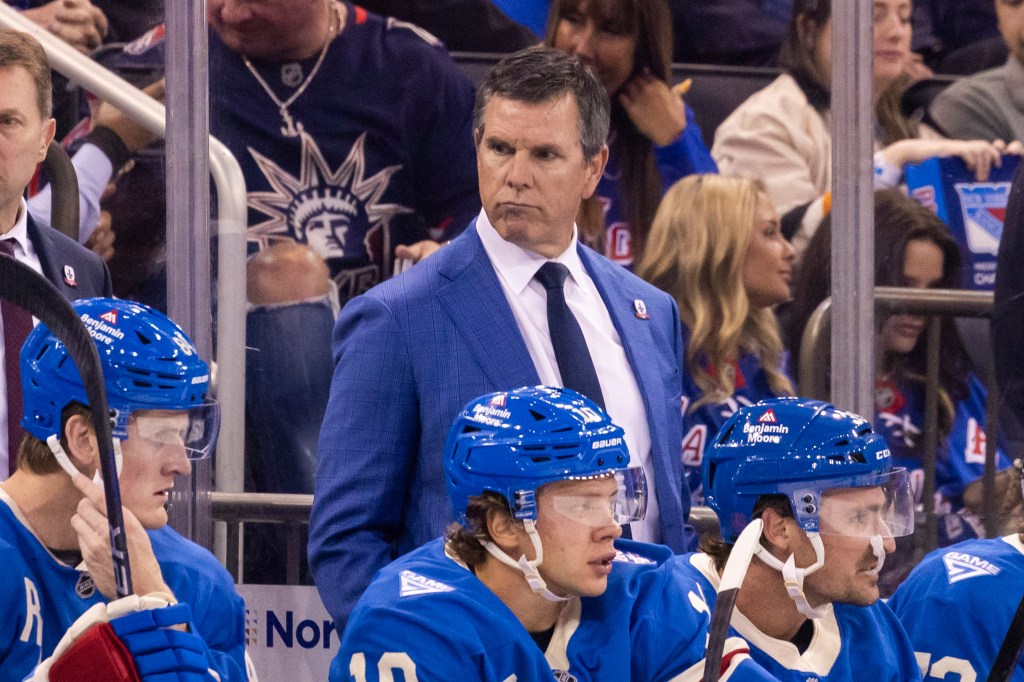 New York Rangers head coach Mike Sullivan standing behind players on the bench during a game against the Pittsburgh Penguins.