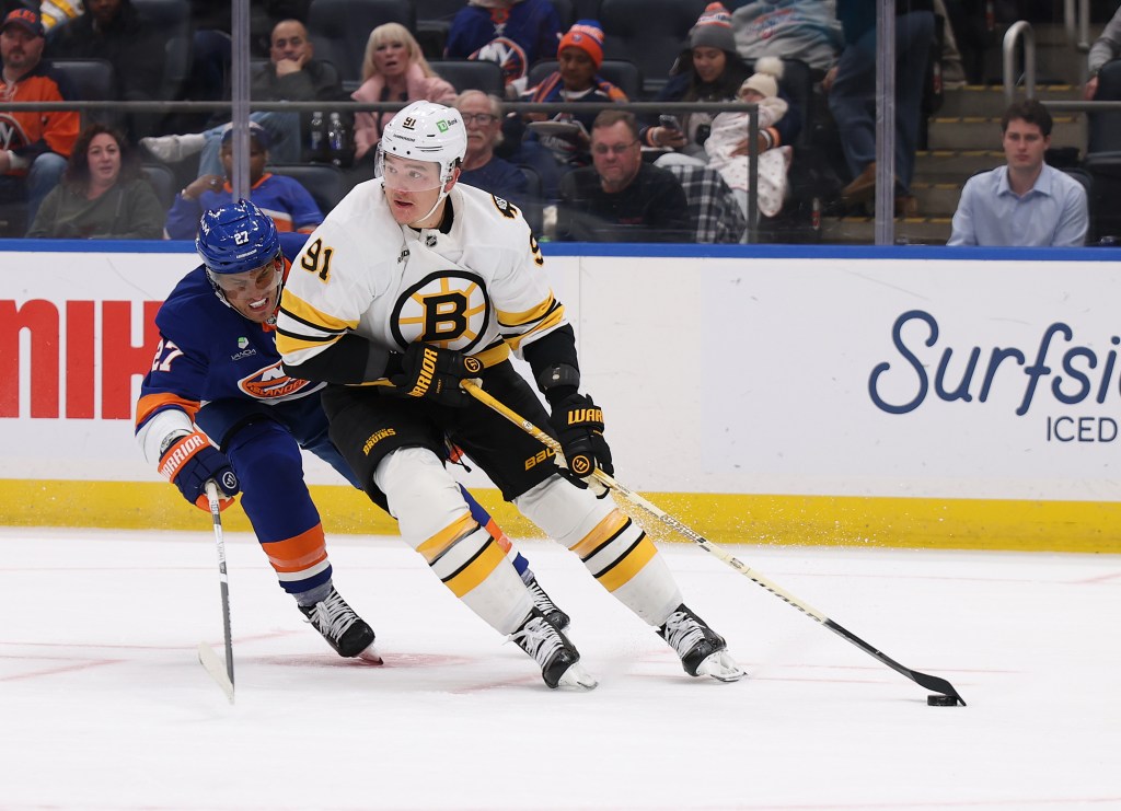 Nikita Zadorov #91 of the Boston Bruins skates against Anders Lee #27 of the New York Islanders.