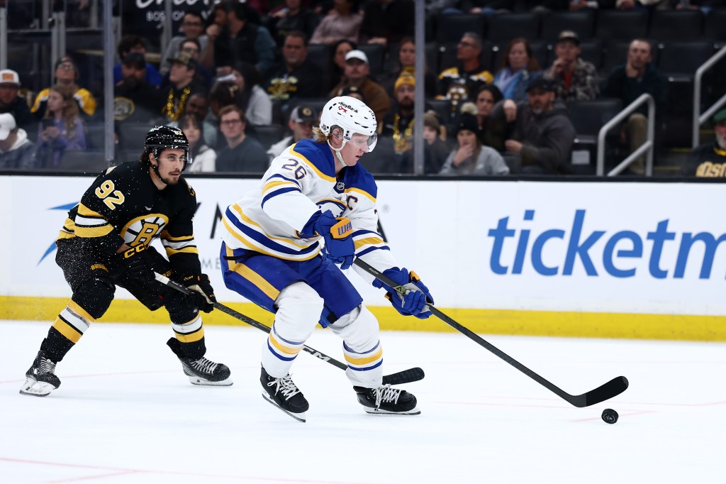 Rasmus Dahlin of the Buffalo Sabres skates against Marat Khusnutdinov of the Boston Bruins during an ice hockey game.