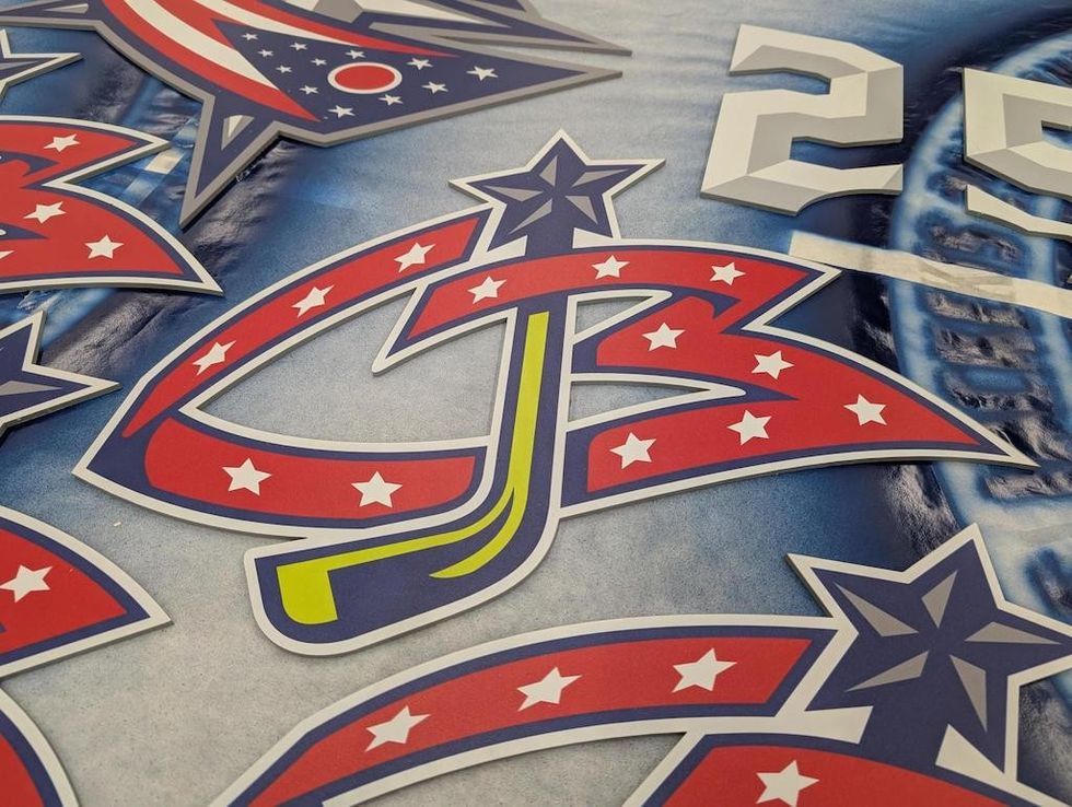 Red and blue star-patterned hockey logo on an icy background.