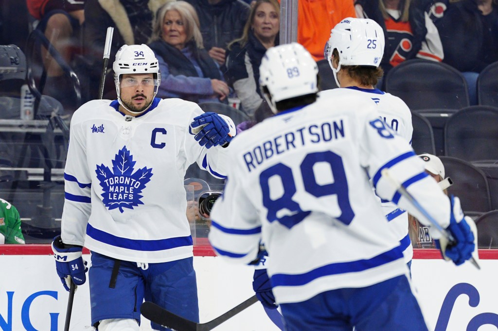 Auston Matthews celebrates his goal with Brandon Carlo (25) and Nicholas Robertson (89).