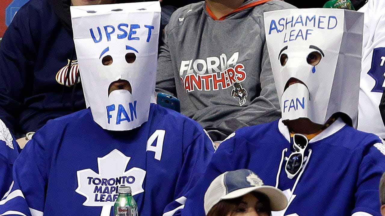 Dejected Toronto Maple Leafs fans in the stands symbolizing their failing 2025-26 season.