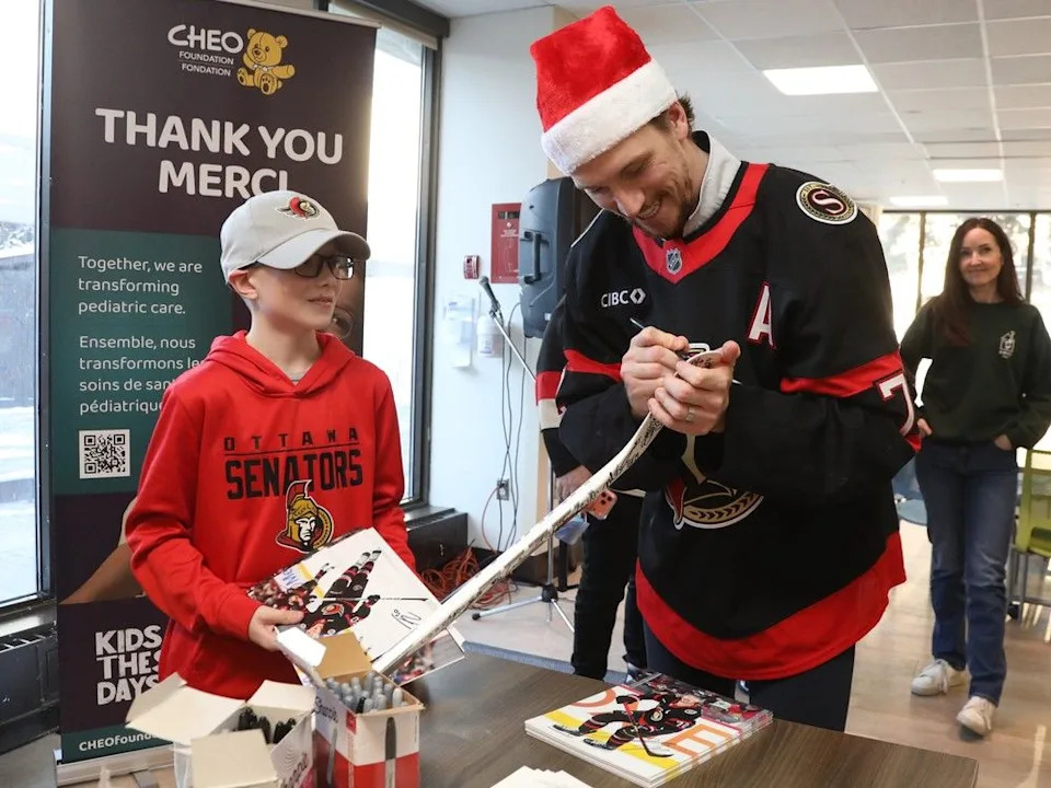  Thomas Chabot of the Ottawa Senators signs the stick of Parker McDonald, 11 years old.