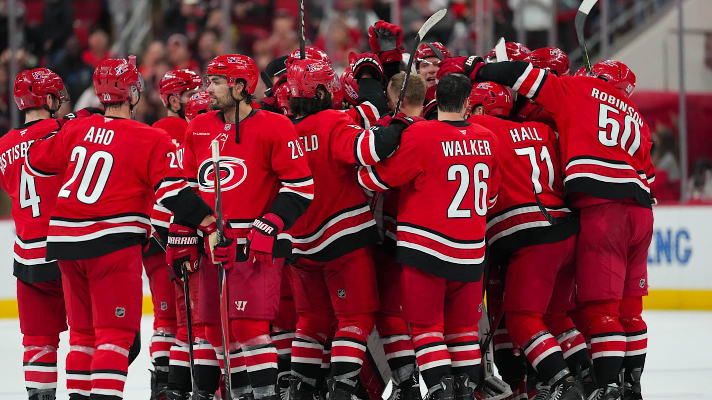 Nov 30, 2025; Raleigh, North Carolina, USA;  Carolina Hurricanes players celebrate their victory against the Calgary Flames in the over time at Lenovo Center. Mandatory Credit: James Guillory-Imagn Images