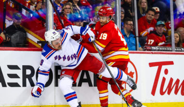 Oct 26, 2025; Calgary, Alberta, CAN; New York Rangers center Sam Carrick (39) and Calgary Flames defenseman Zayne Parekh (19) battles for the puck during the third period at Scotiabank Saddledome. Mandatory Credit: Sergei Belski-Imagn Images