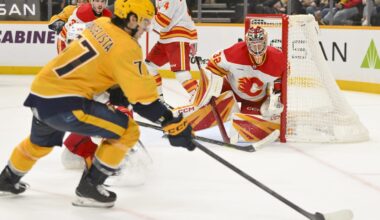 Dec 2, 2025; Nashville, Tennessee, USA;  Calgary Flames goaltender Dustin Wolf (32) blocks the shot of Nashville Predators right wing Luke Evangelista (77) during the third period at Bridgestone Arena. Mandatory Credit: Steve Roberts-Imagn Images