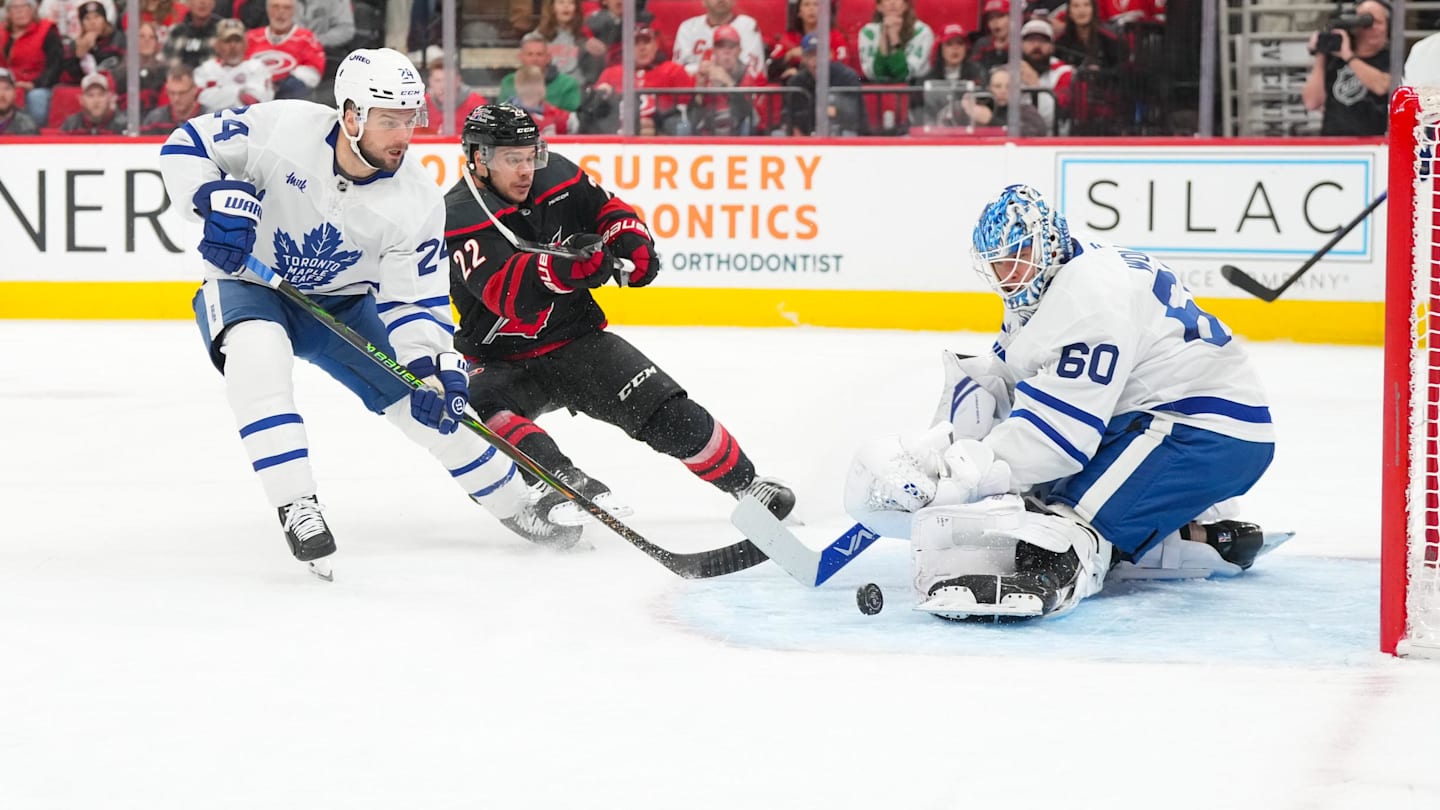 Dec 4, 2025; Raleigh, North Carolina, USA; Toronto Maple Leafs goaltender Joseph Woll (60) with center Scott Laughton (24) stops the scoring attempt by Carolina Hurricanes center Logan Stankoven (22) during the first period at Lenovo Center. Mandatory Credit: James Guillory-Imagn Images