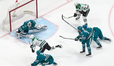Feb 8, 2025; San Jose, California, USA; Dallas Stars center Colin Blackwell (15) looks on as center Wyatt Johnston (53) shoots the puck against San Jose Sharks goaltender Vitek Vanecek (41), defenseman Henry Thrun (3), and centers Will Smith (2) and Andrew Poturalski (22) during the third period at SAP Center at San Jose. Mandatory Credit: Robert Edwards-Imagn Images