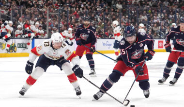 Blue Jackets defenseman Dante Fabbro tries to keep the puck away from Panthers forward Sam Reinhart.