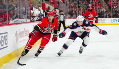 Jan 23, 2025; Raleigh, North Carolina, USA;  Carolina Hurricanes center Sebastian Aho (20) and Columbus Blue Jackets defenseman Zach Werenski (8) chase after the puck during the first period at Lenovo Center. Mandatory Credit: James Guillory-Imagn Images