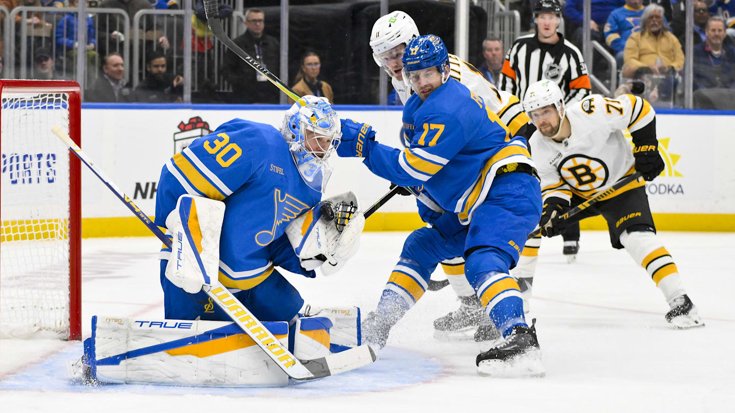 Dec 9, 2025; St. Louis, Missouri, USA; St. Louis Blues goaltender Joel Hofer (30) and defenseman Cam Fowler (17) defend the net against Boston Bruins center Casey Mittelstadt (11) during the first period at Enterprise Center. Mandatory Credit: Jeff Curry-Imagn Images