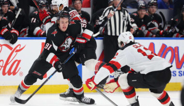 Nov 28, 2025; Buffalo, New York, USA;  Buffalo Sabres right wing Josh Doan (91) plays the puck as New Jersey Devils center Cody Glass (12) defends during the second period at KeyBank Center. Mandatory Credit: Timothy T. Ludwig-Imagn Images