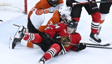 Dec 23, 2025; Chicago, Illinois, USA;  Chicago Blackhawks center Colton Dach (34) fight for the puck with Philadelphia Flyers defenseman Emil Andrae (36) during the third period at United Center. Mandatory Credit: Matt Marton-Imagn Images