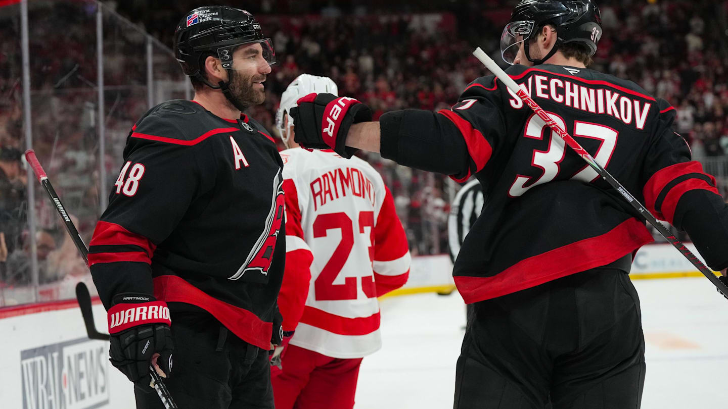Dec 27, 2025; Raleigh, North Carolina, USA;  Carolina Hurricanes left wing Jordan Martinook (48) celebrates his empty net goal with right wing Andrei Svechnikov (37) against the Detroit Red Wings during the third period at Lenovo Center. Mandatory Credit: James Guillory-Imagn Images