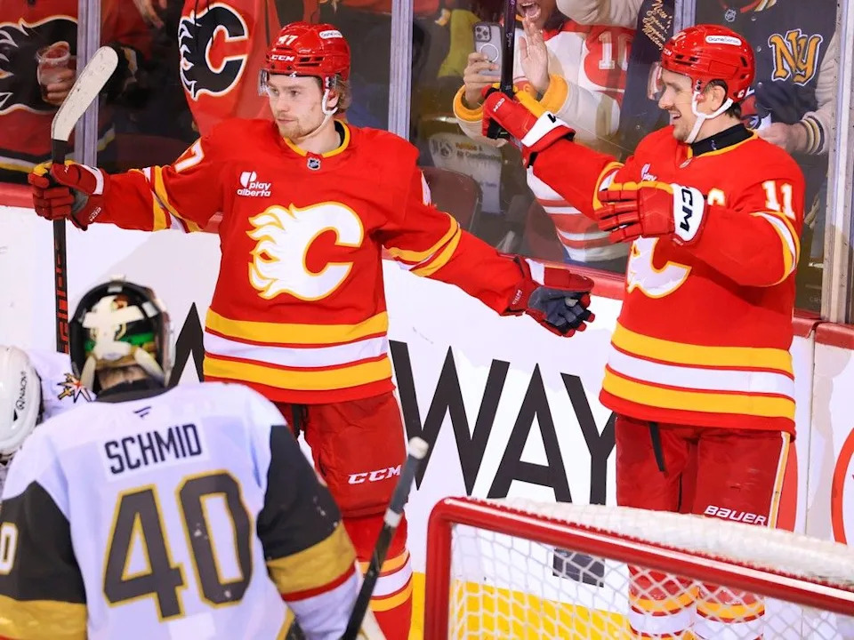 Flames forwards Connor Zary and Mikael Backlund (11) celebrate Backlund’s second goal during Saturday’s game.