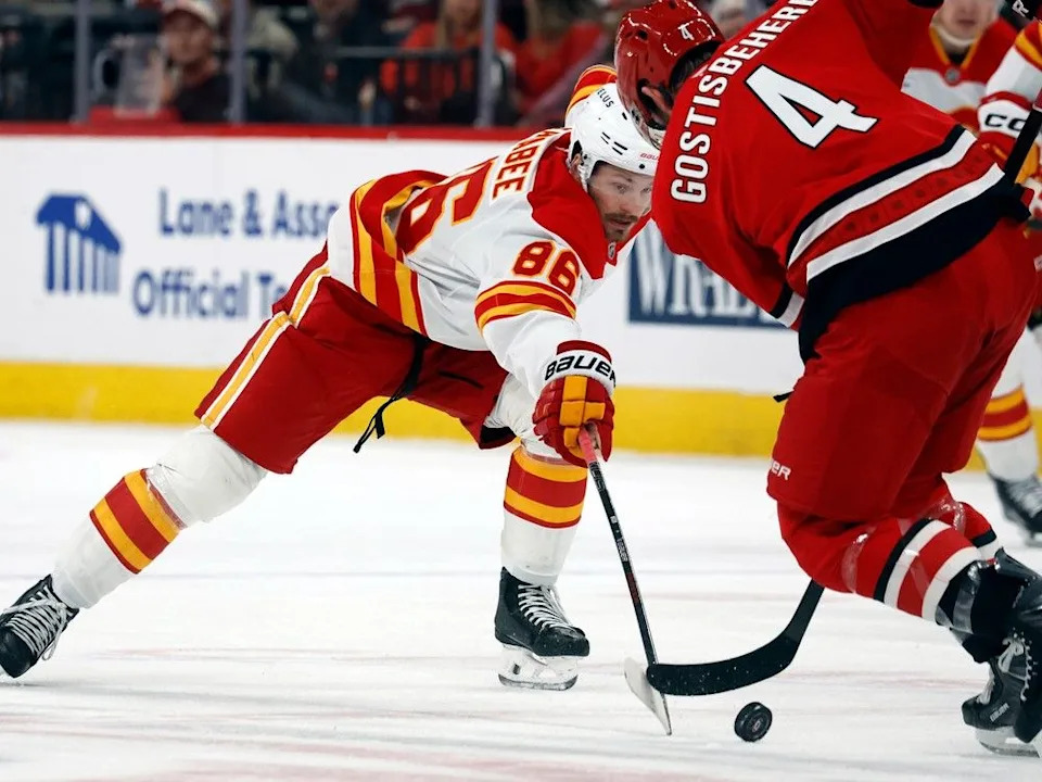  Flames forward Joel Farabee stretches for the puck as he approaches Hurricanes defenceman Shayne Gostisbehere.