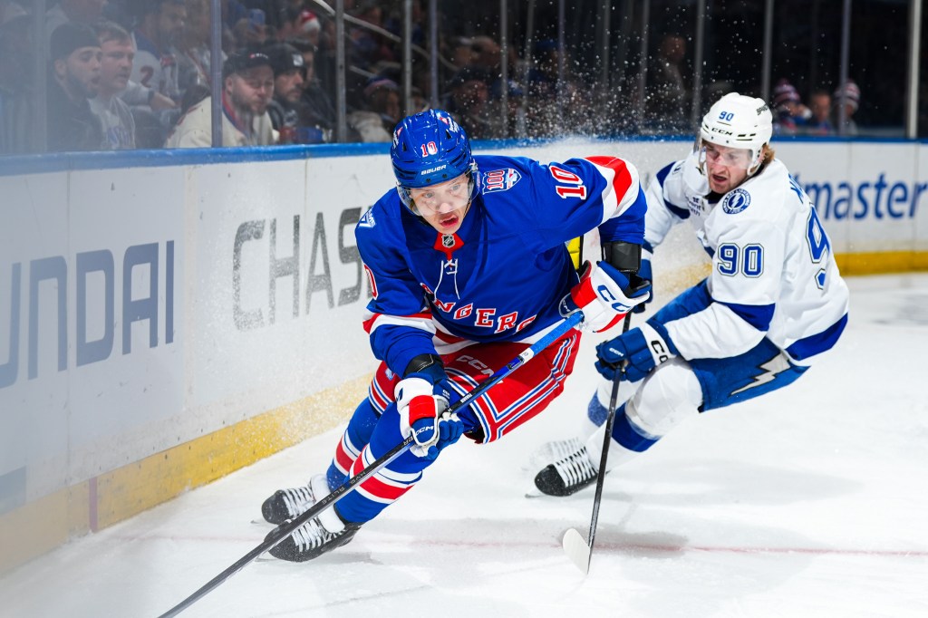 Artemi Panarin of the New York Rangers skating with the puck, pursued by J.J. Moser of the Tampa Bay Lightning.
