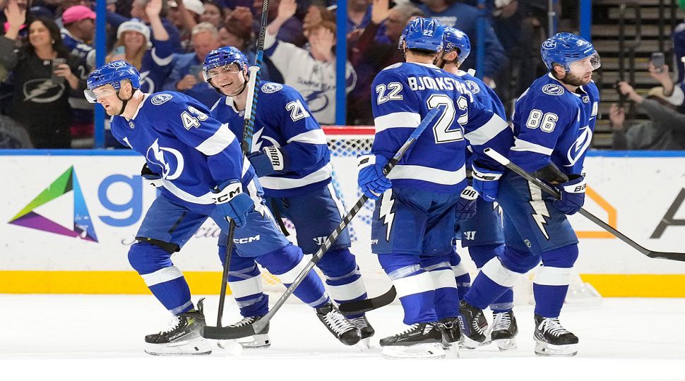 Tampa Bay Lightning defenseman Darren Raddysh (43) celebrates his goal against the St. Louis Blues with teammates, including center Brayden Point (21), right wing Oliver Bjorkstrand (22) and right wing Nikita Kucherov (86) during the first period of an NHL hockey game Monday, Dec. 22, 2025, in Tampa, Fla. (AP Photo/Chris O'Meara)