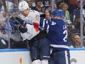 Niko Mikkola of the Florida Panthers is slammed into the boards by Scott Laughton of the Toronto Maple Leafs during a playoff game.