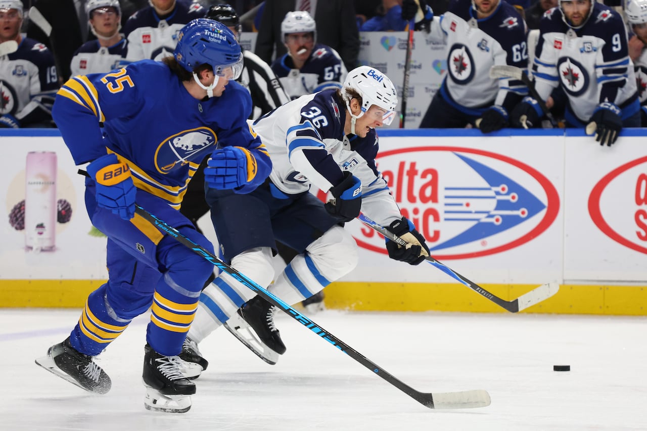 Two hockey players battle for the puck.