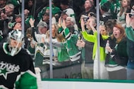 Dallas Stars fans celebrate a goal by center Wyatt Johnston behind goaltender Casey Desmith...