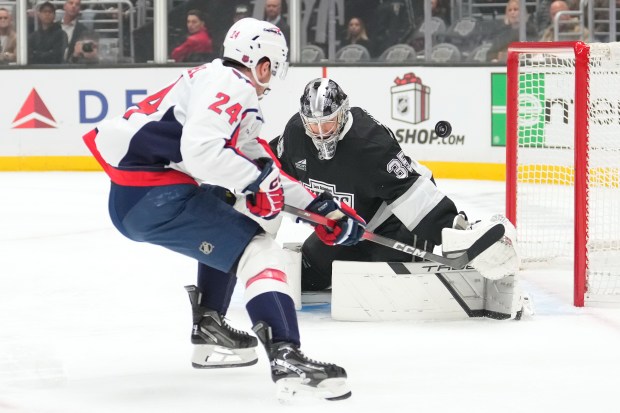 Washington Capitals center Connor McMichael, left, tries to score past...