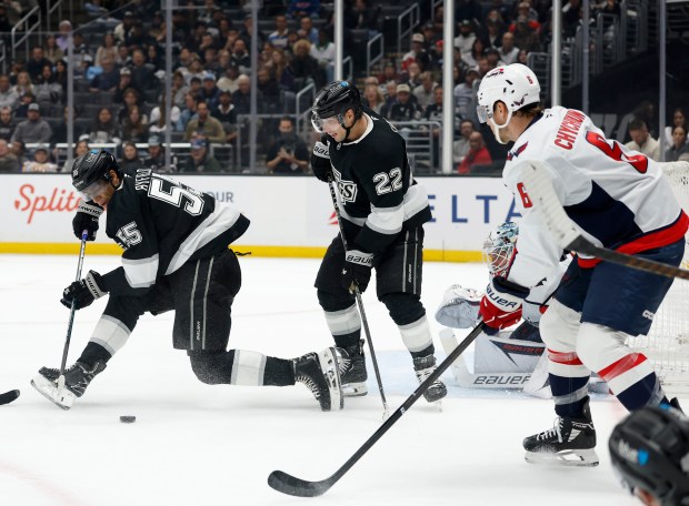 The Kings’ Quinton Byfield, left, plays the puck in front...