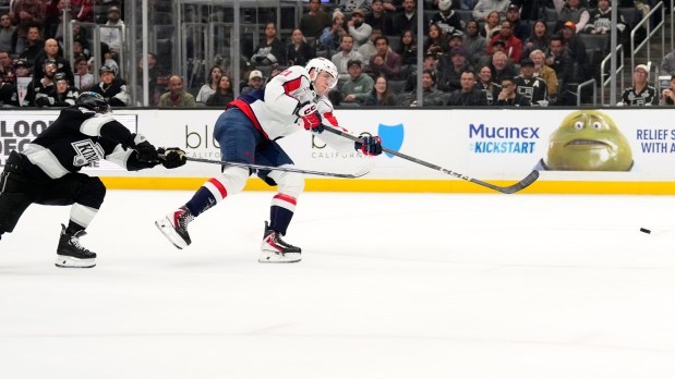 Washington Capitals center Aliaksei Protas, right, scores into an empty...