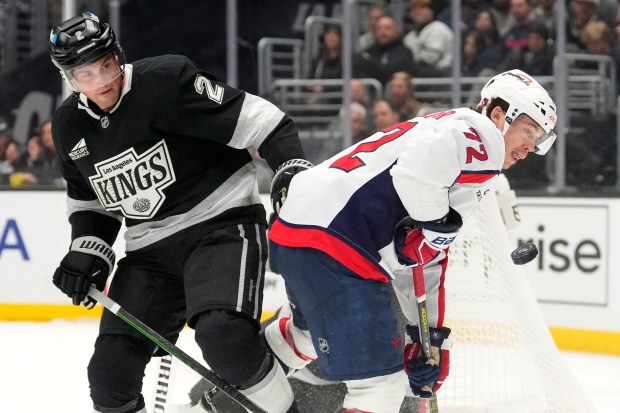 Kings defenseman Brian Dumoulin, left, and Washington Capitals left wing...