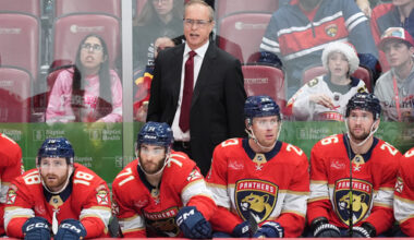 Florida Panthers head coach Paul Maurice stands behind players left wing Noah Gregor (18), center Luke Kunin (71), center Carter Verhaeghe (23), and defenseman Uvis Balinskis (26) during the third period of an NHL hockey game against the Calgary Flames, Friday, Nov. 28, 2025, in Sunrise, Fla. (AP Photo/Rebecca Blackwell)