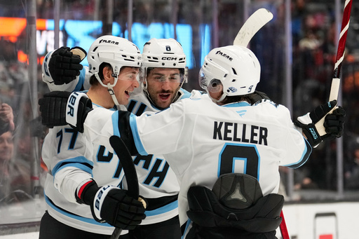 Utah Mammoth right wing JJ Peterka left, celebrates his goal with center Nick Schmaltz, center, and right wing Clayton Keller during the second period of an NHL hockey game against the Anaheim Ducks, Wednesday, Dec. 3, 2025, in Anaheim, Calif. (AP Photo/Mark J. Terrill)